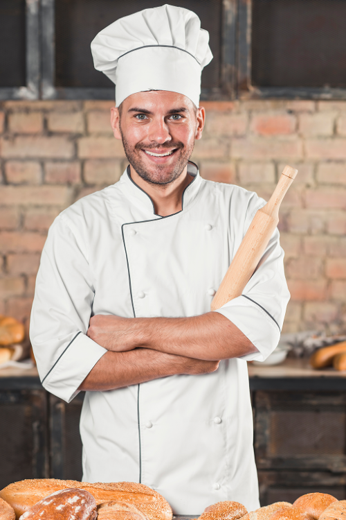 portrait-de-souriant-boulanger-male-debout-derriere-les-pains-sur-table 1